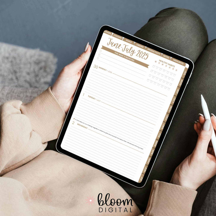 User holding an iPad with a June-July 2025 digital planner page from Bloom Daily Planners.