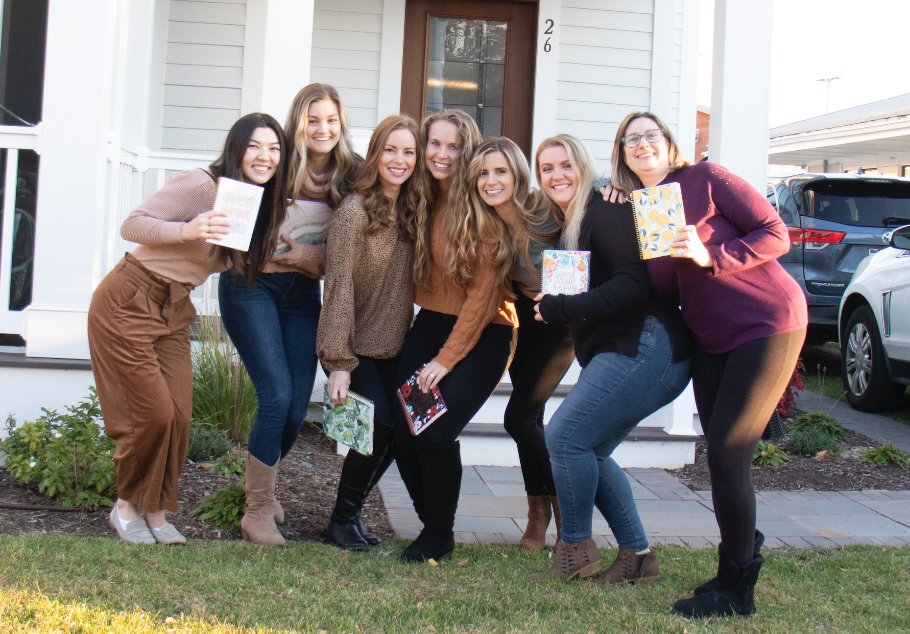 Group of women standing outside holding planners.