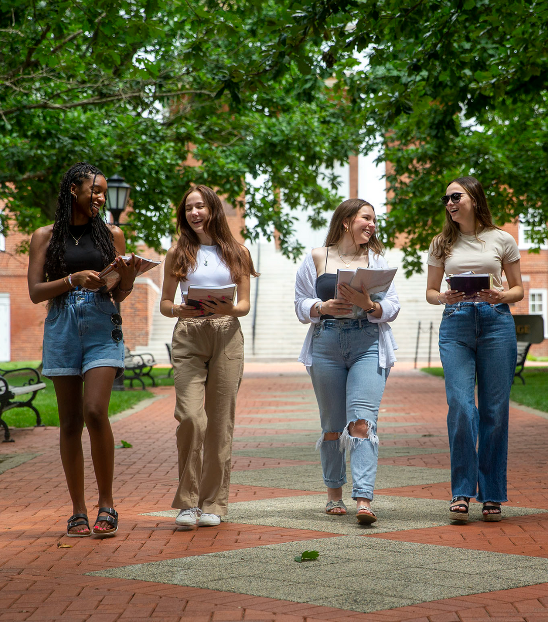 Four girls walking on a college campus caring planners.