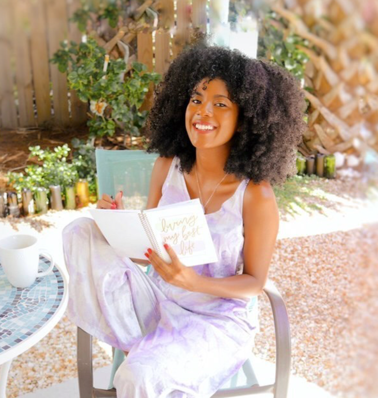 Photo of a woman holding her planner outside.