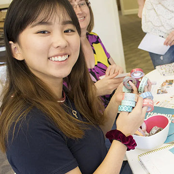 girls holding washi tape decorating their vision boards