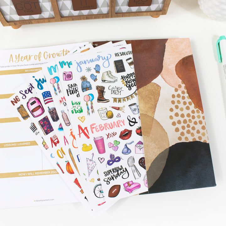 Vintage holiday hand-drawn planner stickers in January and February designs, displayed with a colorful planner.