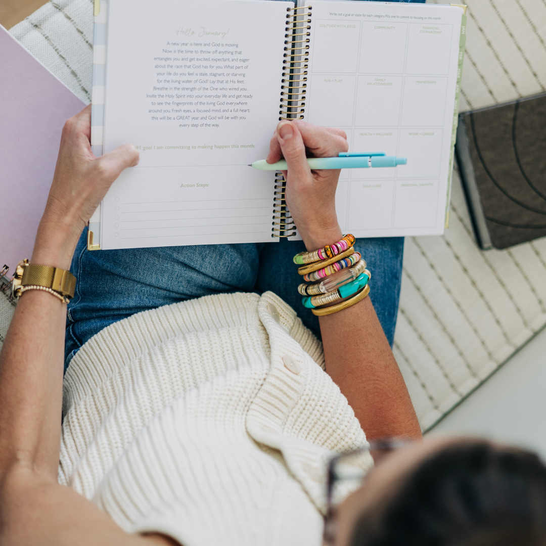 A woman planning her month in a beautiful and simple planner