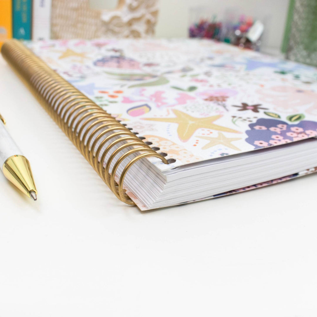 Close-up of 2027 soft-cover planner with gold spiral binding and patterned pages