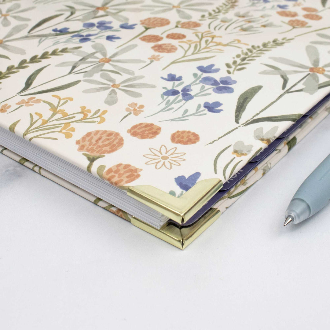 2027 hard-cover planner open, showing wildflower cover and ribbon bookmark at spine