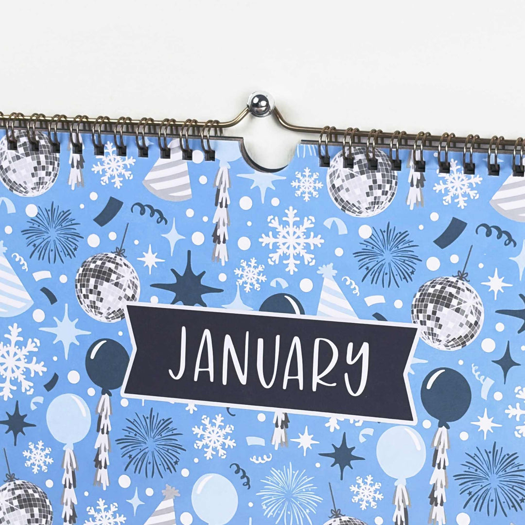 Calendar with a blue winter-themed cover featuring snowflakes, disco balls, and the word 'January'.