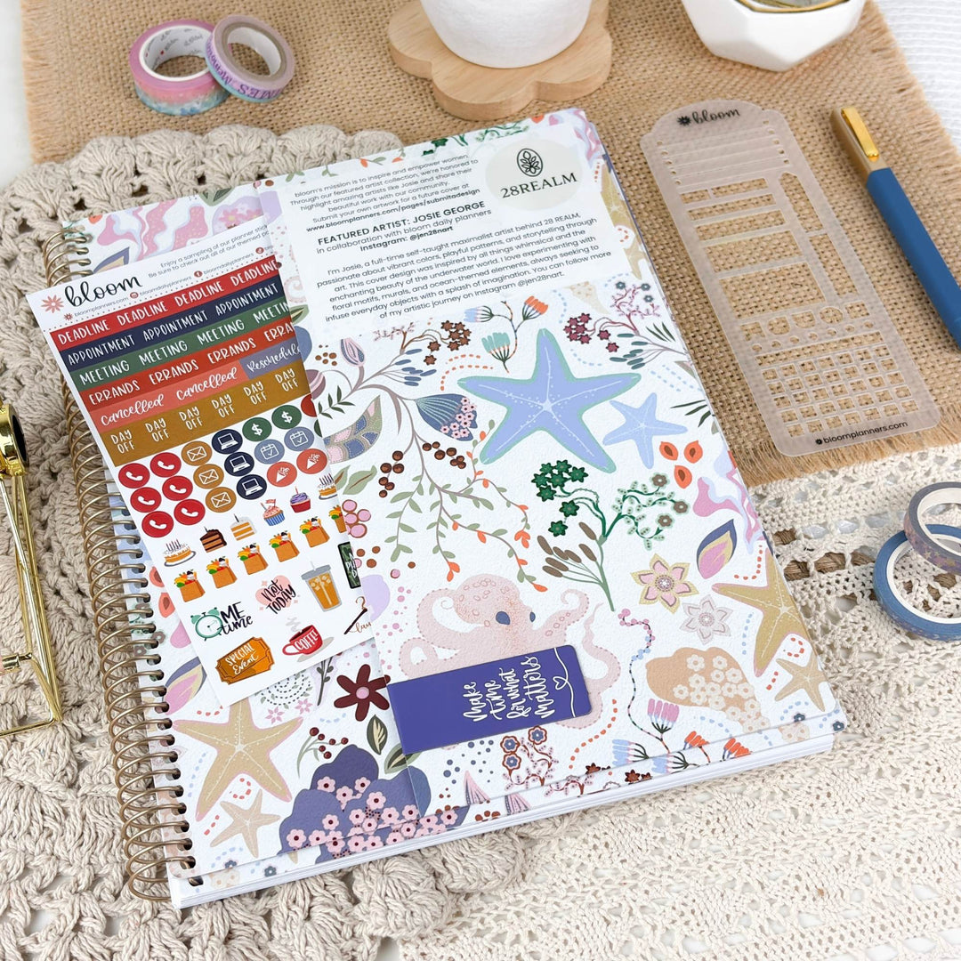 2027 planner opened to stickers and notes layout on tabletop, spiral binding visible