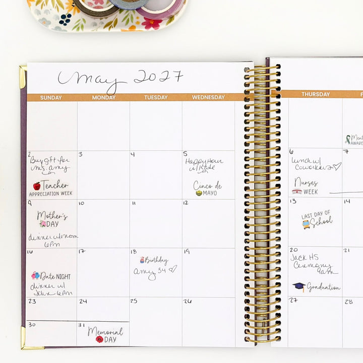 Monthly planner page with handwritten notes and holiday celebration sticker accents
