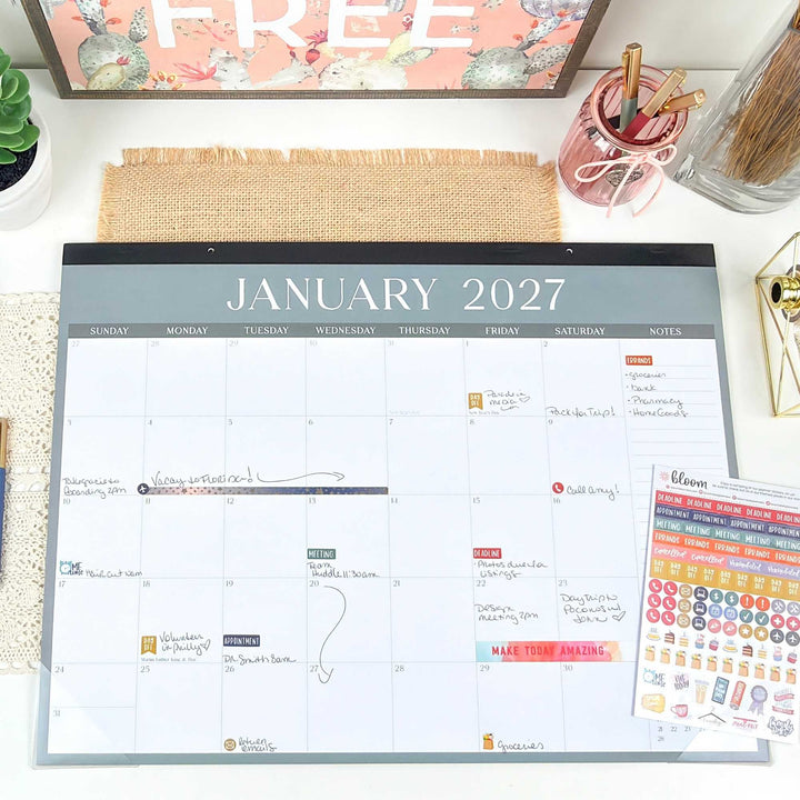 A decorated January 2027 spread of a large desk calendar on a desk with stickers and washi tape. 