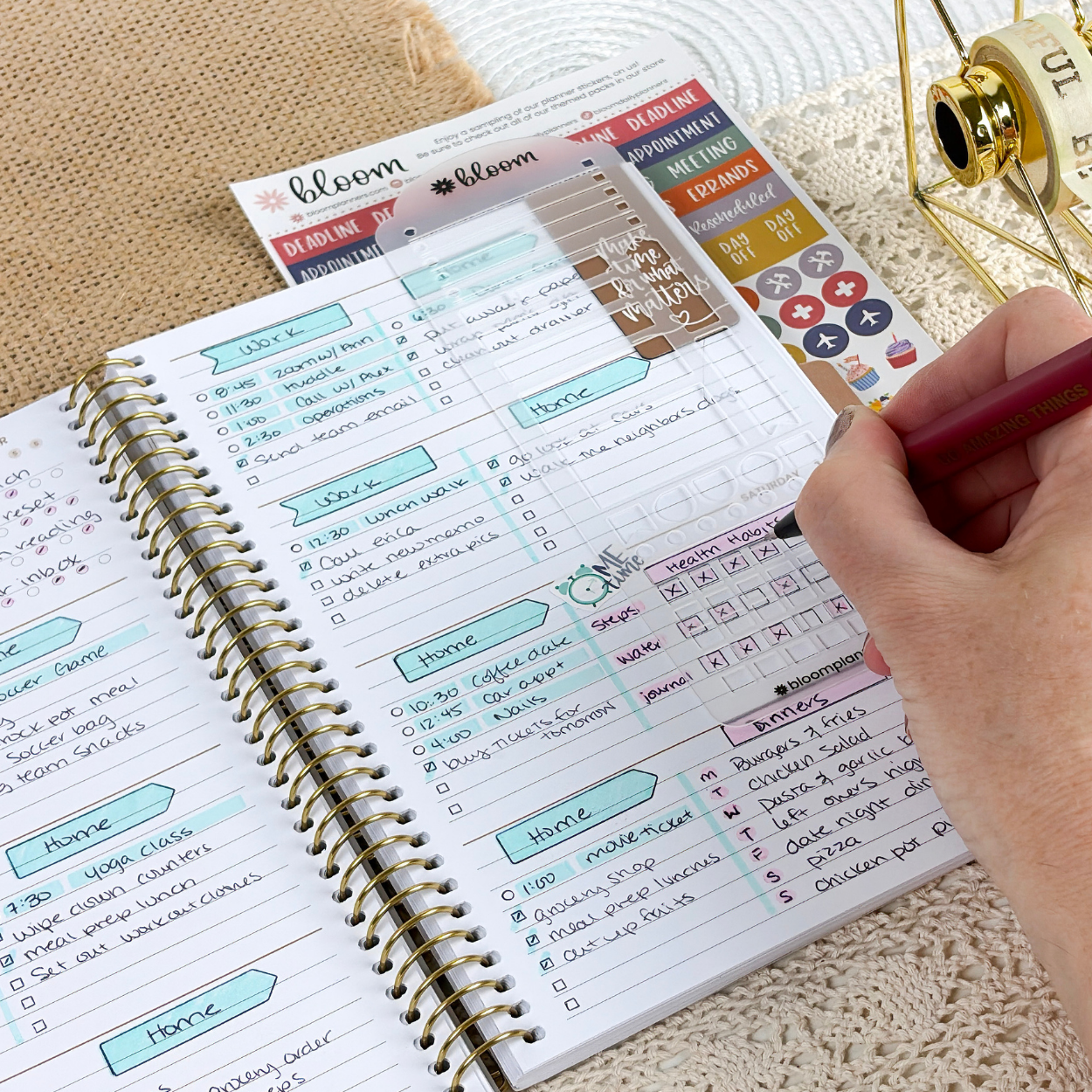 Person writing in the weekly view of a 2027 bloom planner with a stencil visible. 