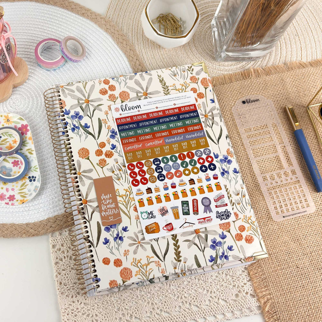 2027 hard-cover planner open to printed grid and colorful sticker icons page