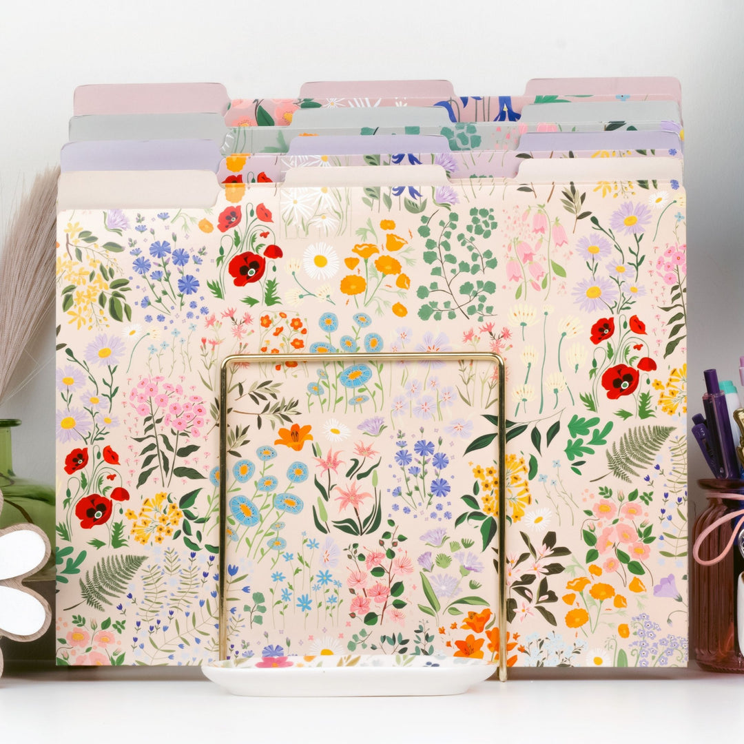 Floral-patterned file folders on a white surface with stationery items.