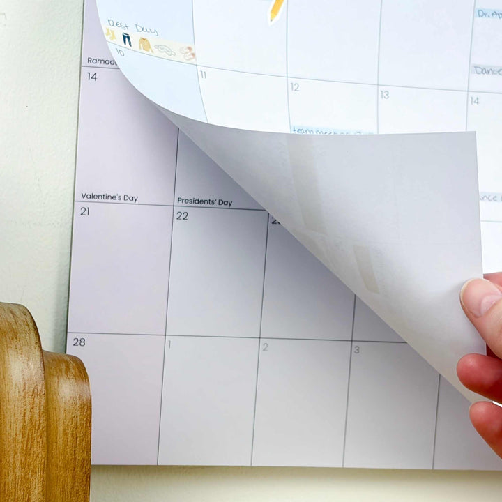 Calendar with a hand peeling off a sheet, revealing a light gray color swatch.