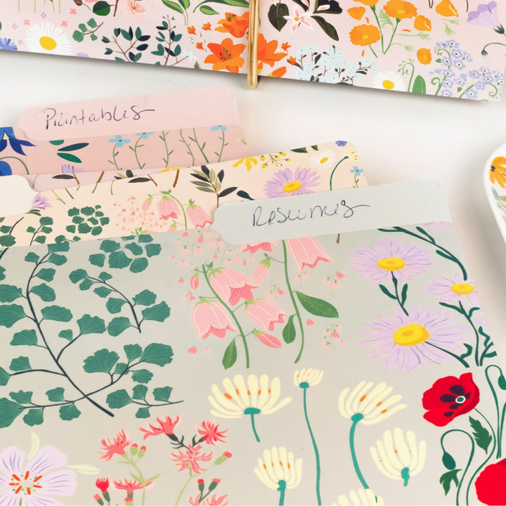 Collection of floral-patterned paper sheets on a white surface