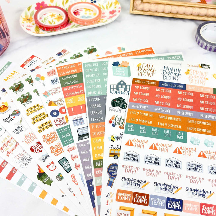 Collection of colorful planner stickers on a white surface with decorative items.