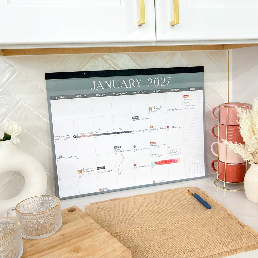 Calendar for January 2027 on a kitchen counter with kitchenware in the background