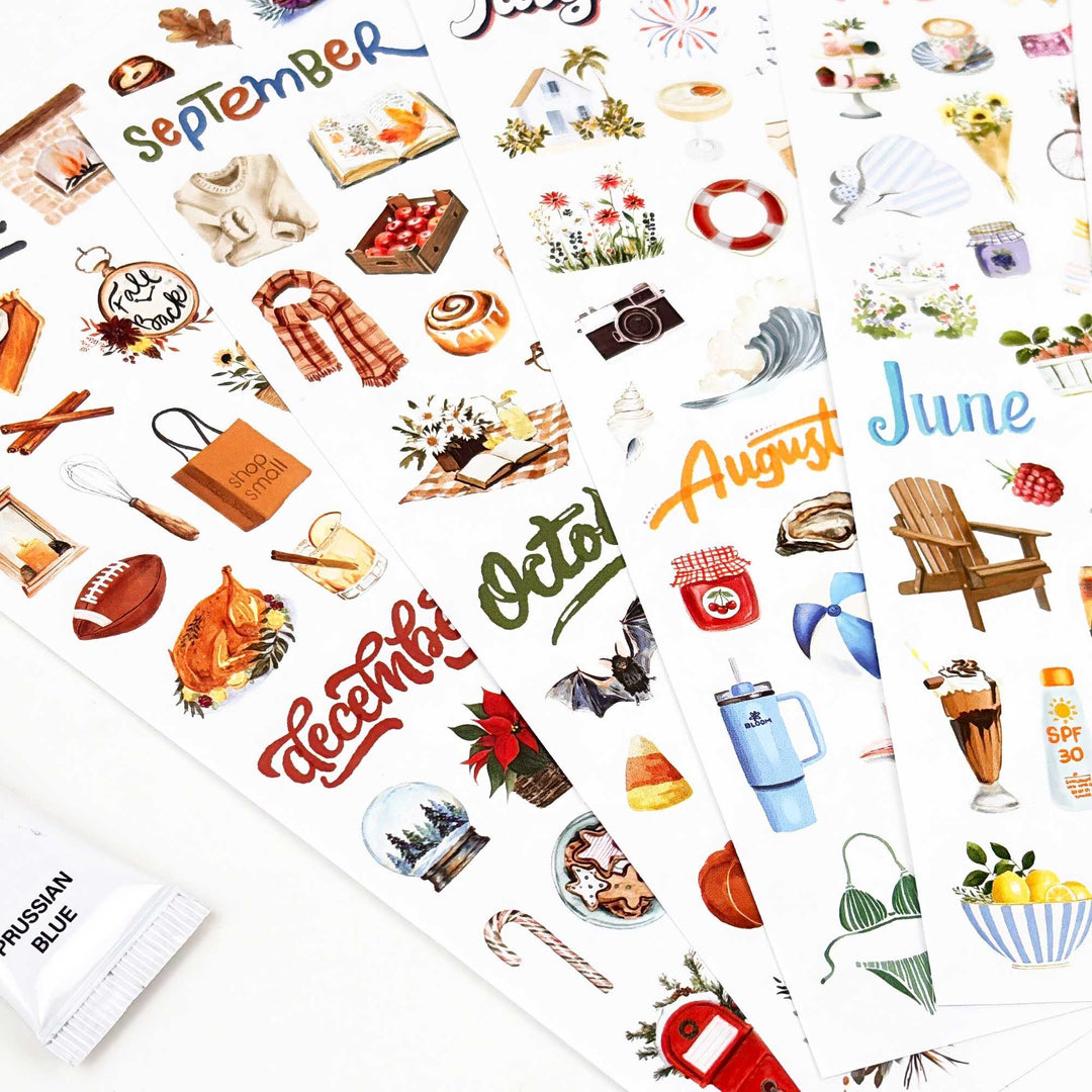 Four sticker sheets fanned with fall and summer months visible up close