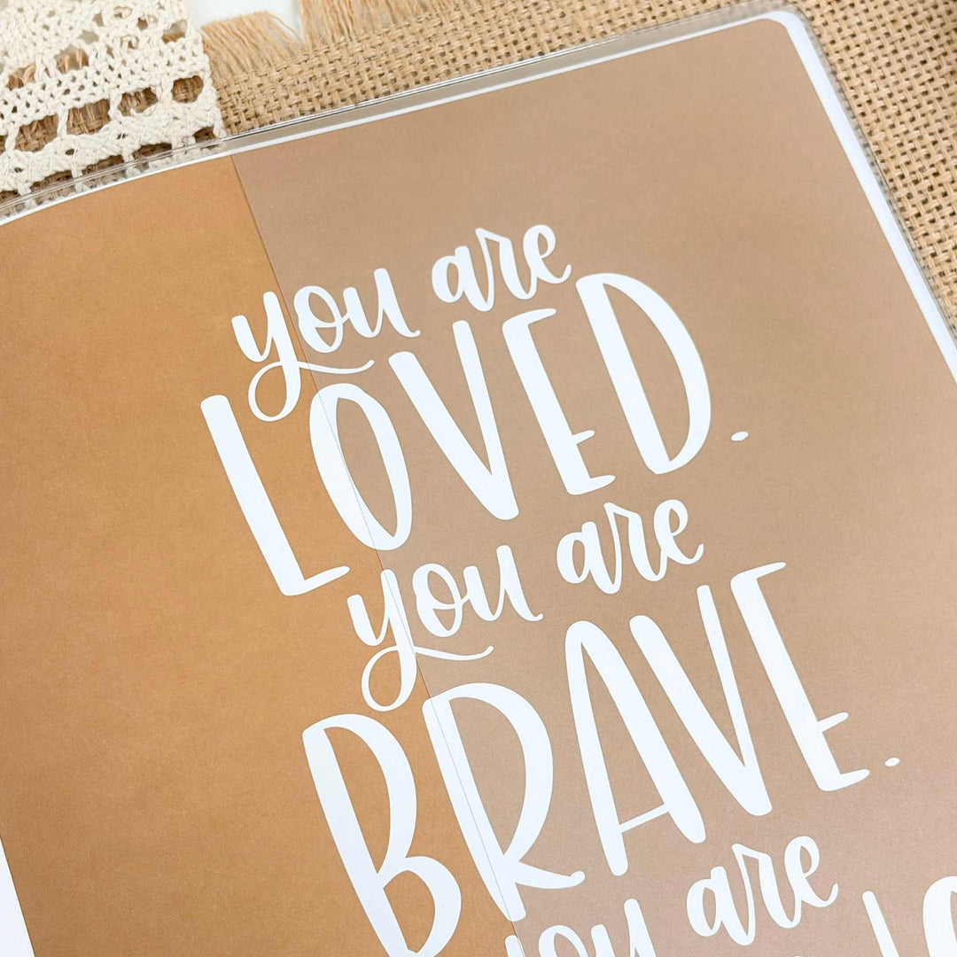 Motivational quote on a brown background with lace and wooden surface.