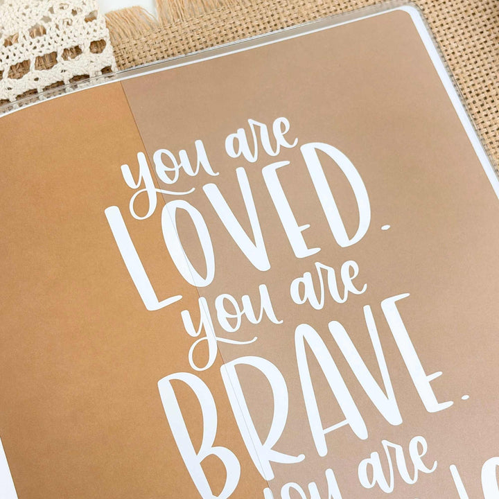 Motivational quote on a brown background with lace and wooden surface.