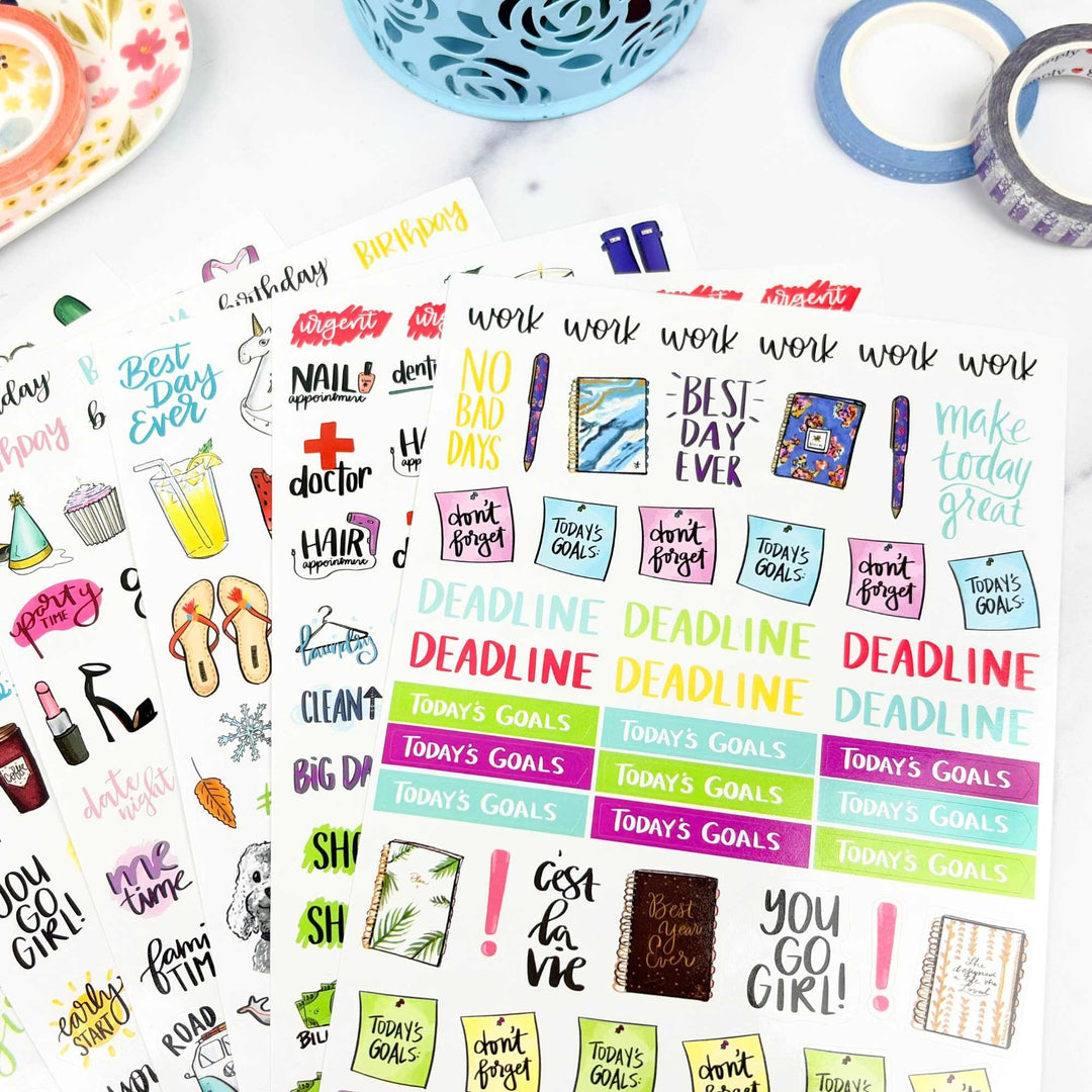 Collection of colorful planner stickers on a white surface with stationery items.