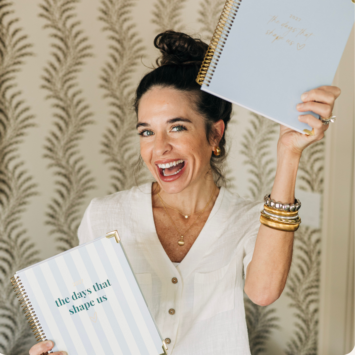 Cleere Cherry founder of Cleerely Stated holding her 2027 planners made in collaboration with bloom daily planners.
