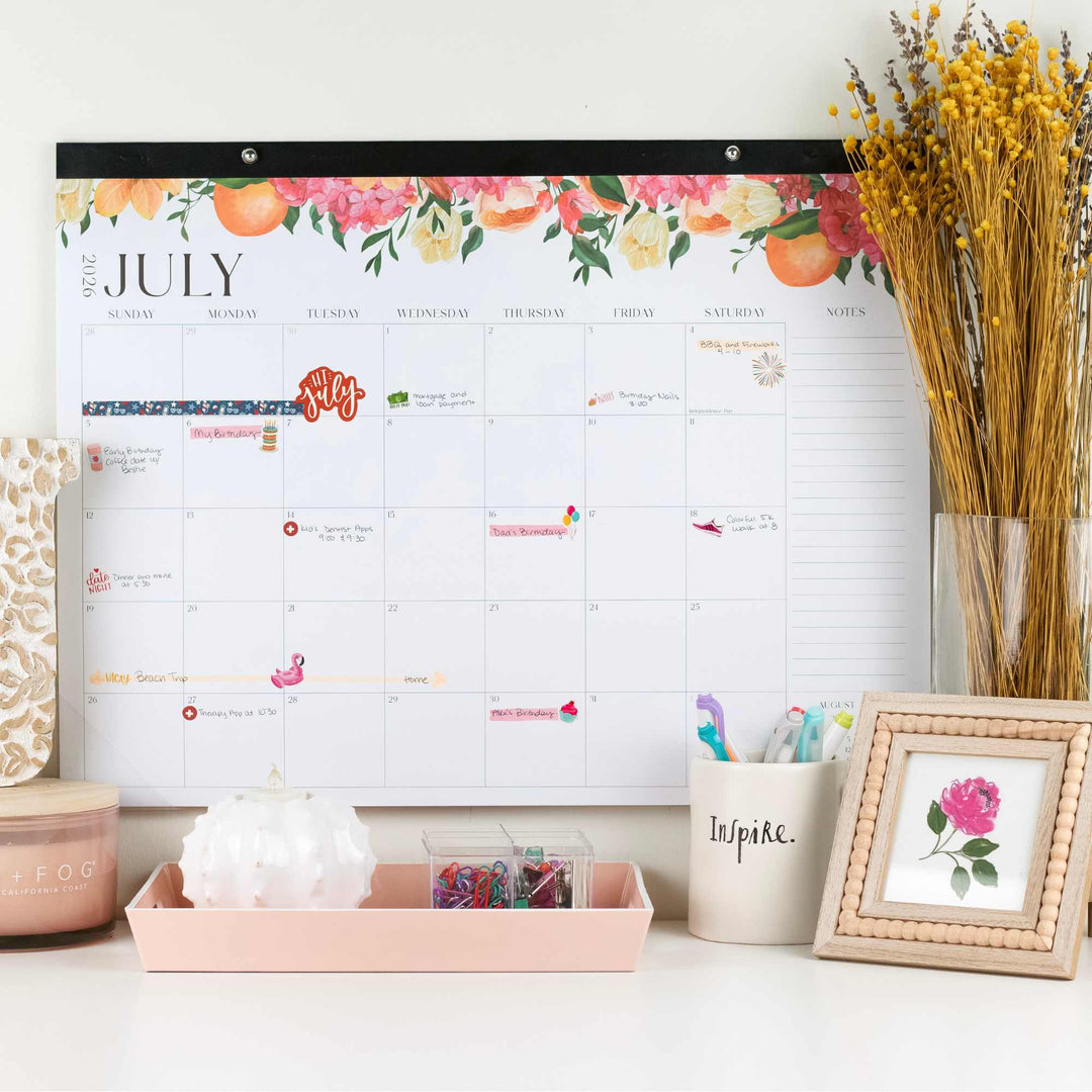 Floral-themed calendar on a wall with decorative items below