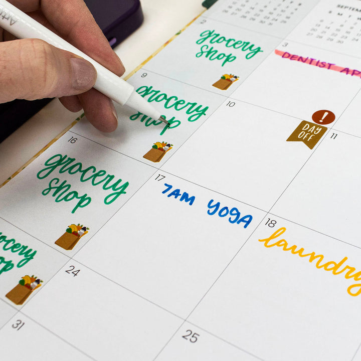 Hand writing on a calendar with markers