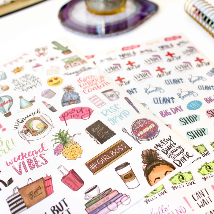 Sheet of colorful stickers with various designs and text on a white surface.