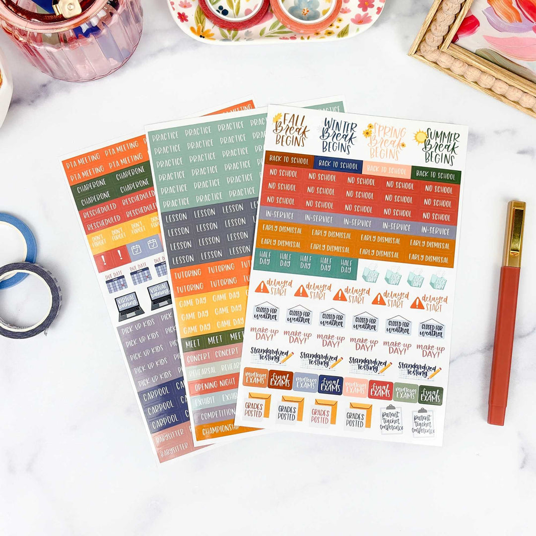 Colorful planner stickers on a white surface with stationery items.