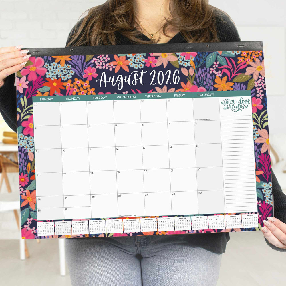 Person holding a floral August 2026 calendar
