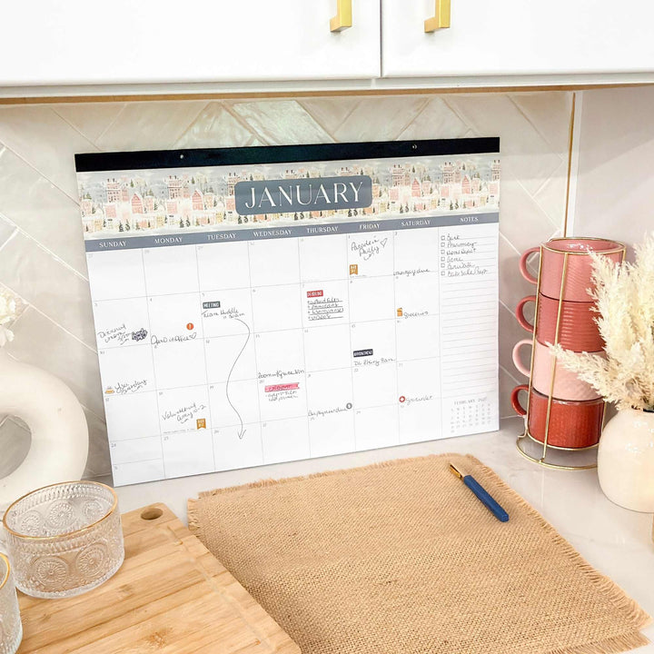 Calendar on a kitchen counter with a cup and decorative items