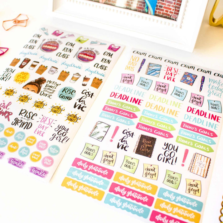 Colorful planner stickers with motivational phrases on a white surface.