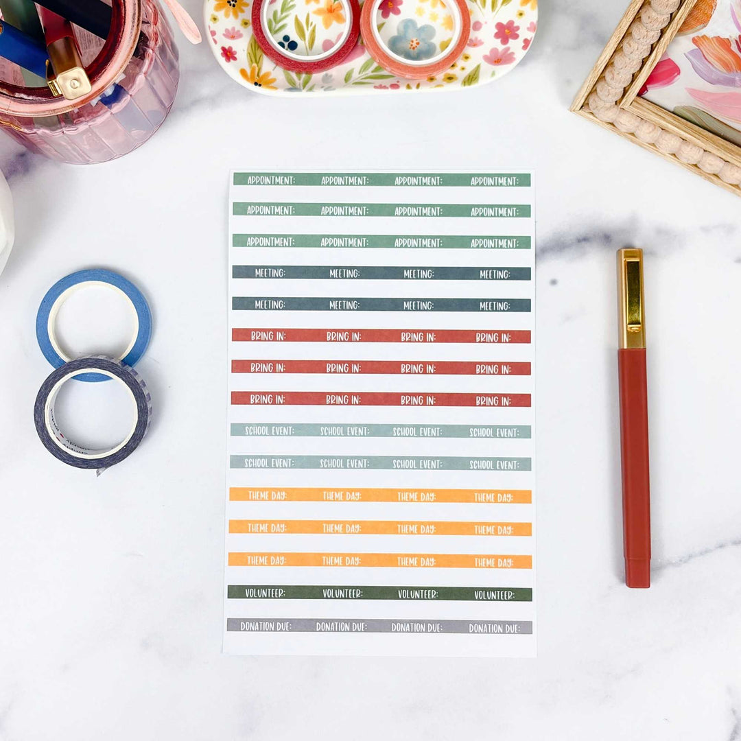 Colorful planner stickers on a white surface with stationery items.