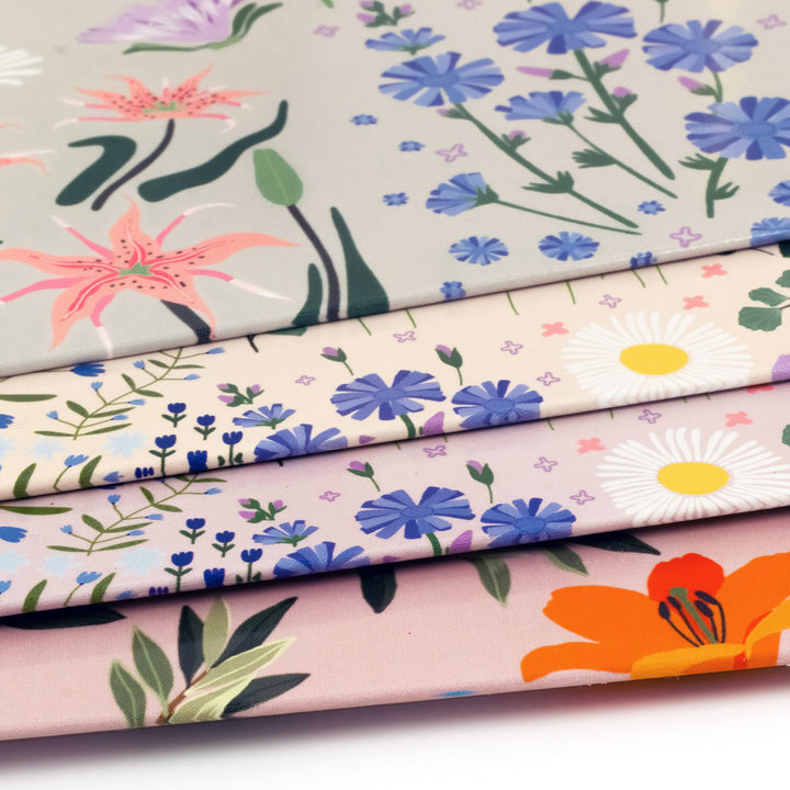 Stack of floral-patterned fabrics with various colors and designs.