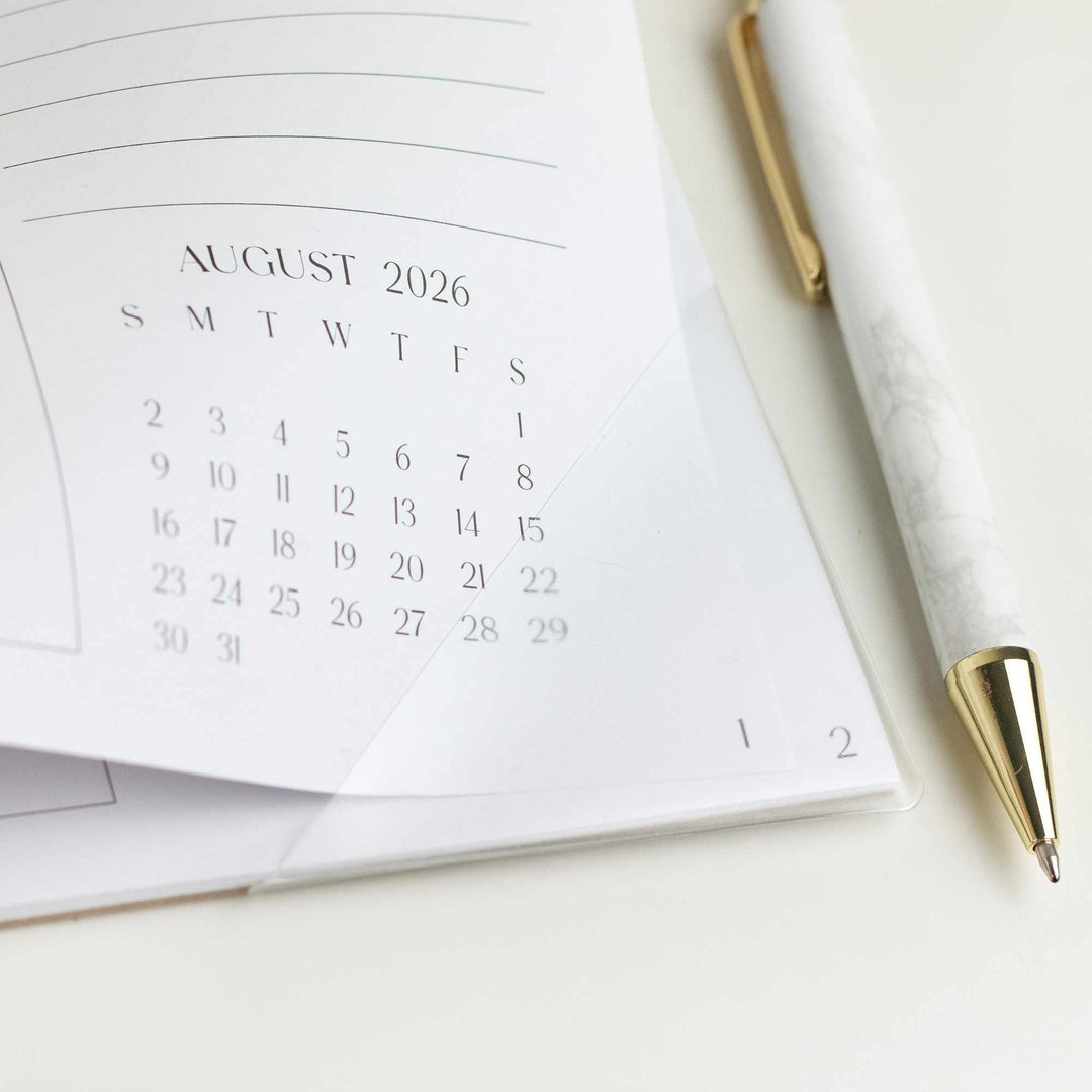 Calendar for August 2026 with a pen on a white surface