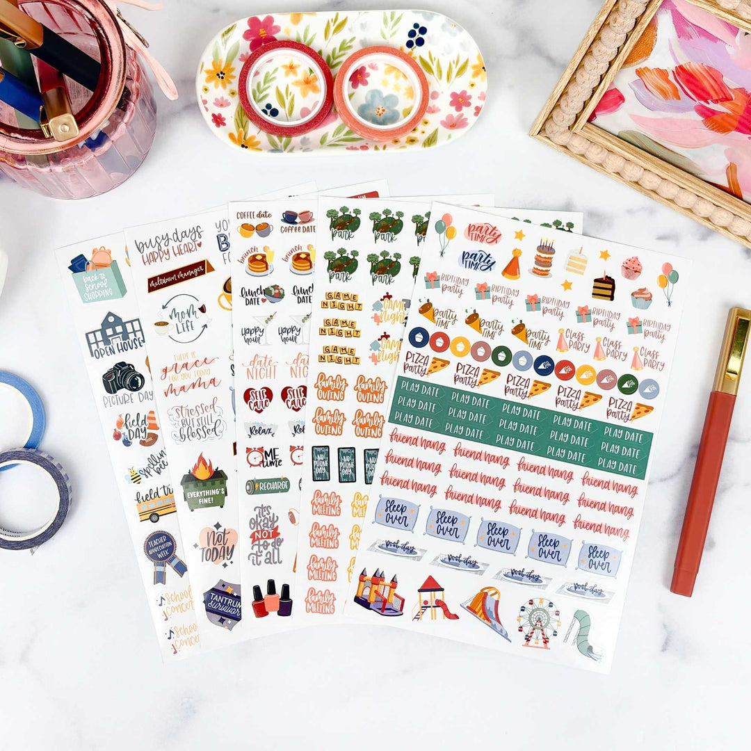 Sheet of colorful planner stickers with various designs on a white surface.