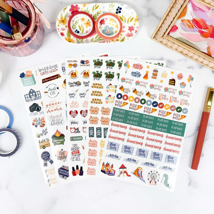 Sheet of colorful planner stickers with various designs on a white surface.
