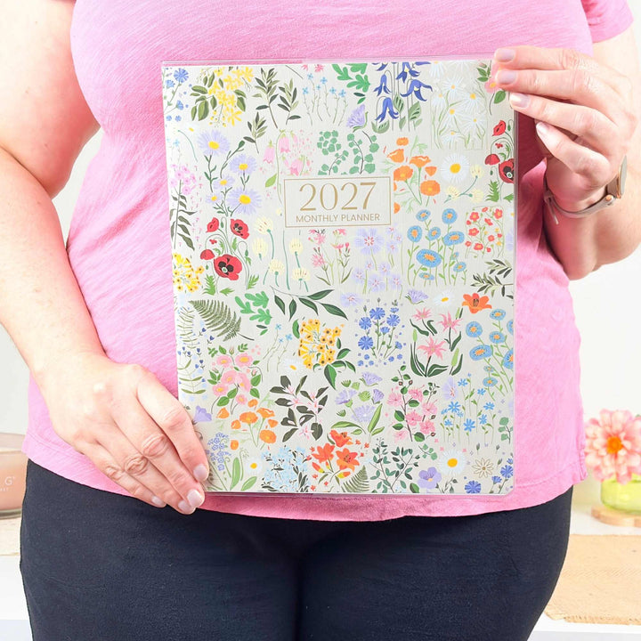 Person holding a 2027 floral planner