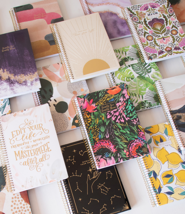 Variety of colorful planners laid out on a desk.