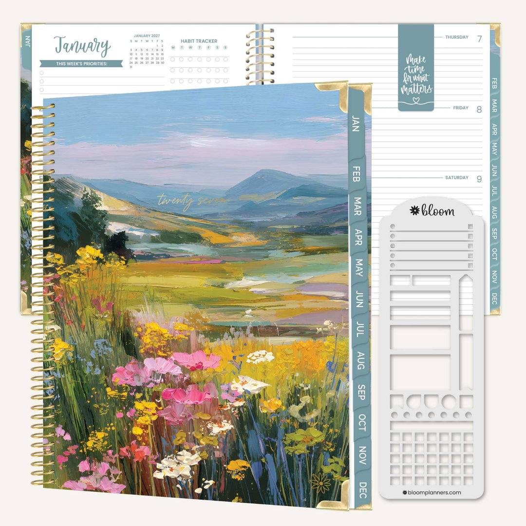 A spiral-bound planner shown open to a landscape page with wildflowers and mountains, alongside interior weekly layout pages and a white monthly insert sheet. The planner has teal vertical tabs and visible bloom branding.