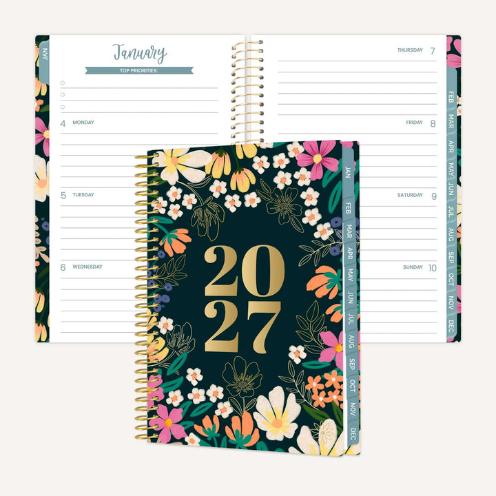A 2027 spiral-bound planner shown open with floral interior pages behind it and the closed front cover in front. The cover is dark teal with large gold '2027' text and a colorful floral border.