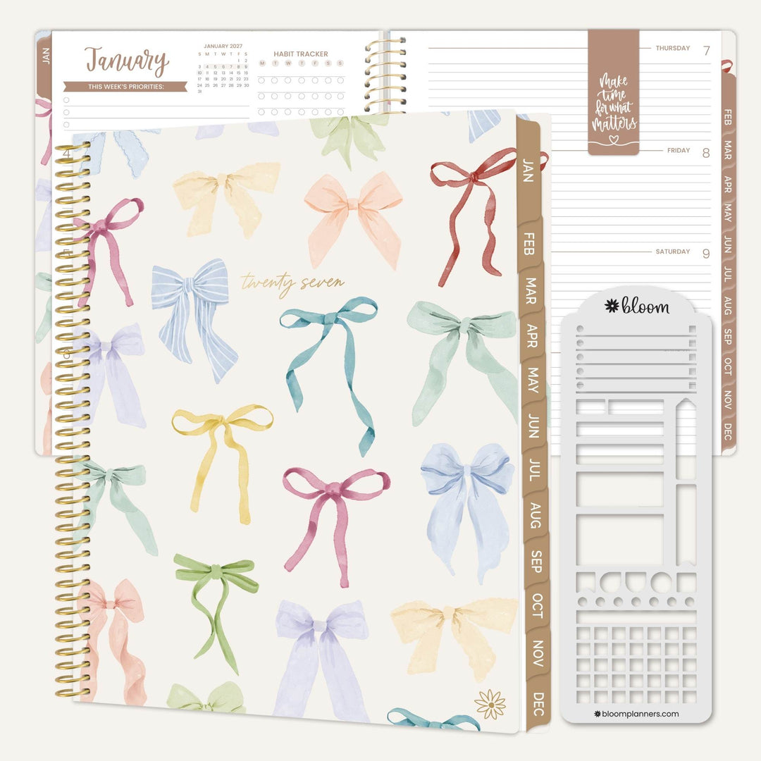 A spiral-bound planner shown open with decorated cover pages and inserts. The main cover features a pastel watercolor bow pattern on an off-white background, with gold spiral binding.