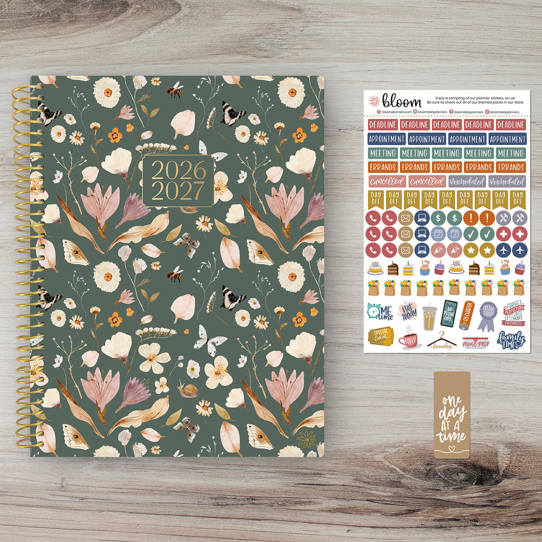 Floral-patterned planner for 2026-2027 with stickers on a wooden surface