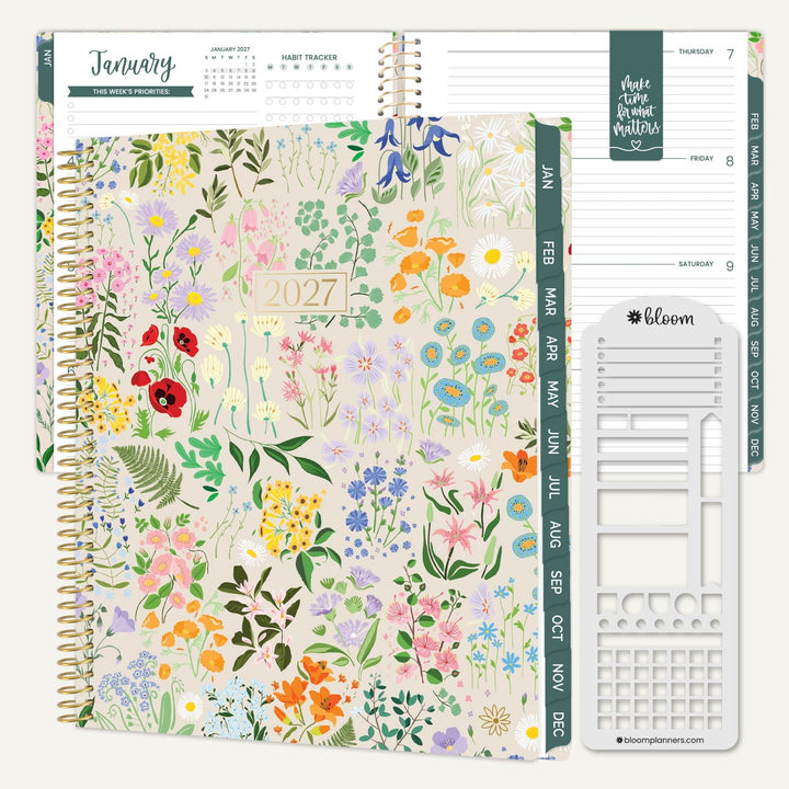 A 2027 spiral-bound planner shown open with floral cover pages, weekly planner inserts, and a white daily planning sheet on a light gray background. The cover features a dense multicolor wildflower pattern on a warm cream base, with teal vertical month tabs and a gold spiral binding.