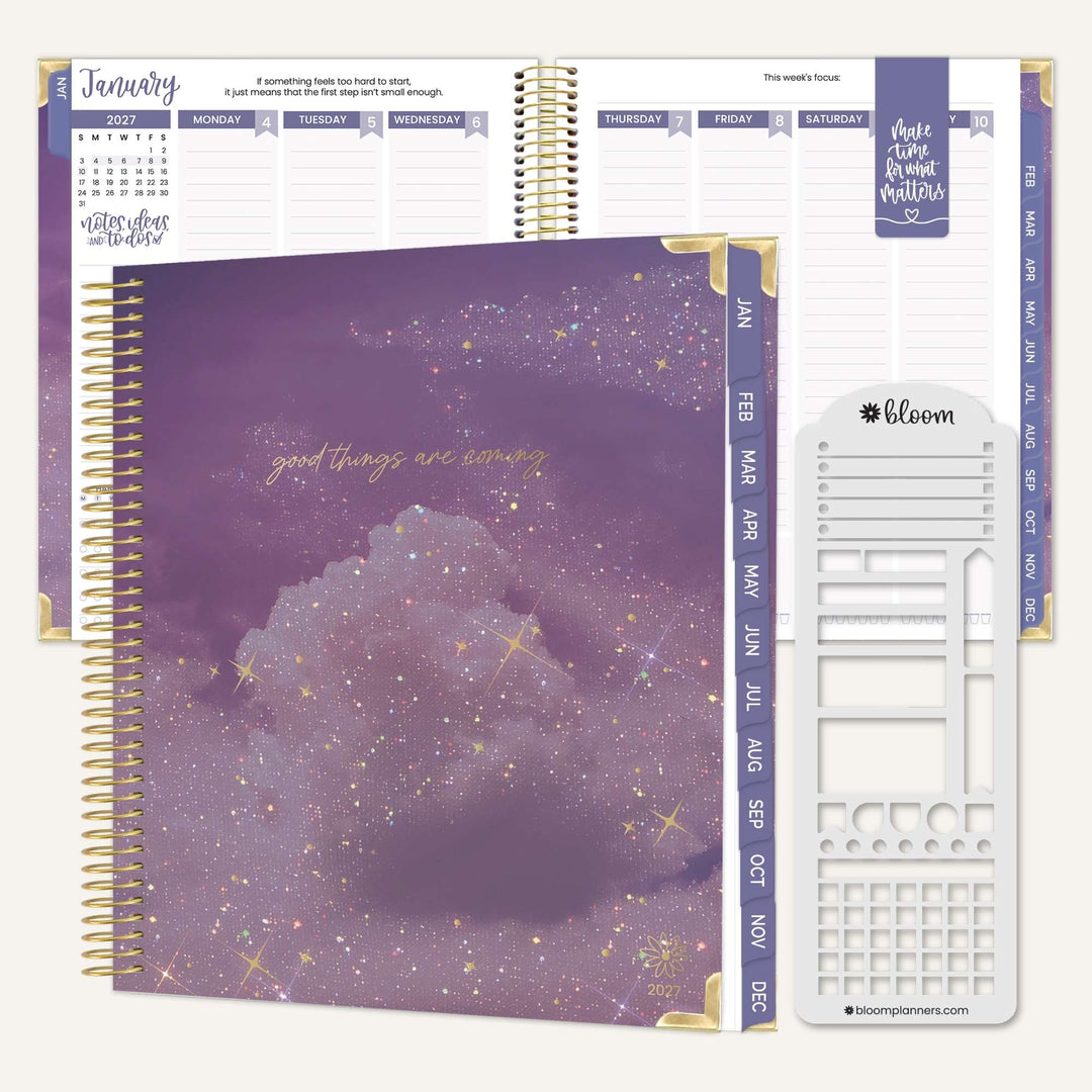 A spiral-bound planner set shown on a light neutral background, featuring a purple glittery cloud cover design with gold foil text, open monthly and weekly planner pages behind it, and a white sticker sheet with gold accents labeled bloom.