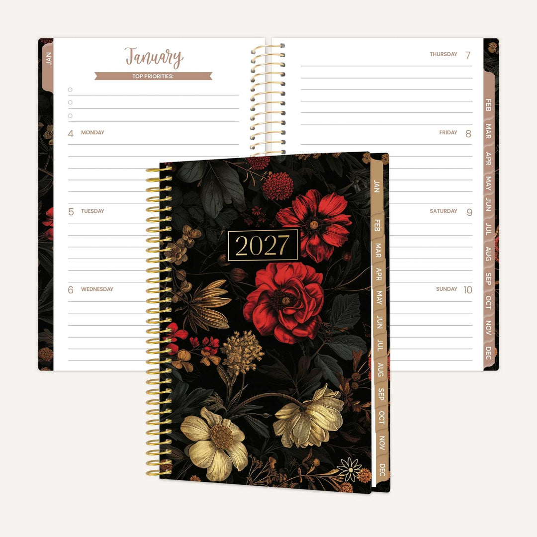 A 2027 spiral-bound planner shown closed in front of an open view of the same planner, with floral cover art featuring red, cream, and gold flowers on a dark background. The open pages show lined daily planning layouts in white with tan headers.