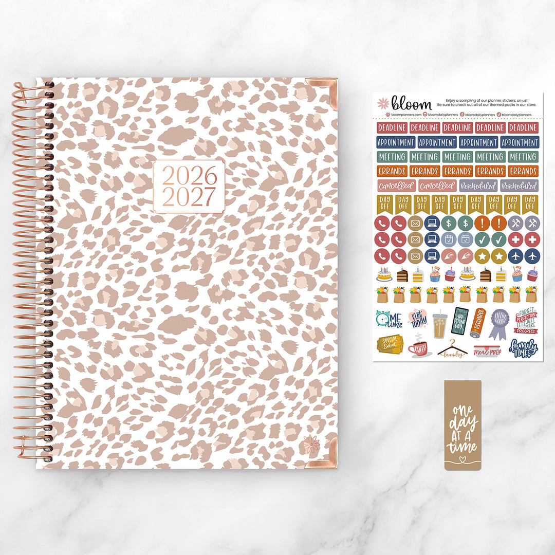 Leopard print planner with stickers and a card on a white background