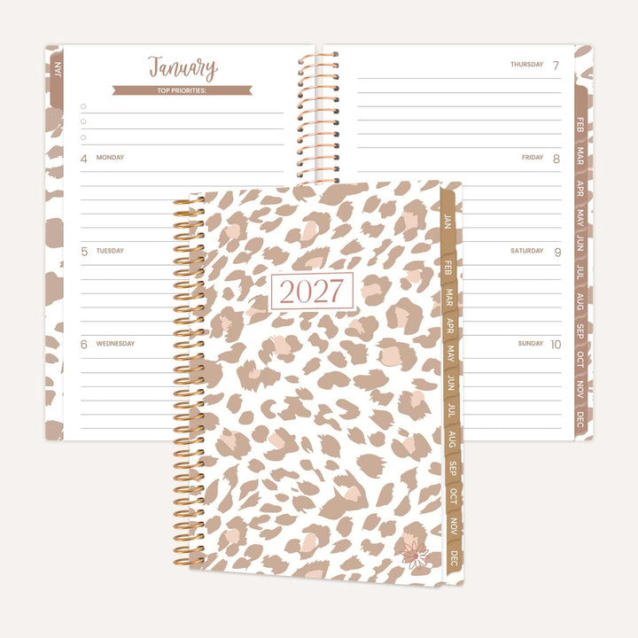 A spiral-bound 2027 planner shown open to a January page and closed with a leopard-print cover, on a light beige background.