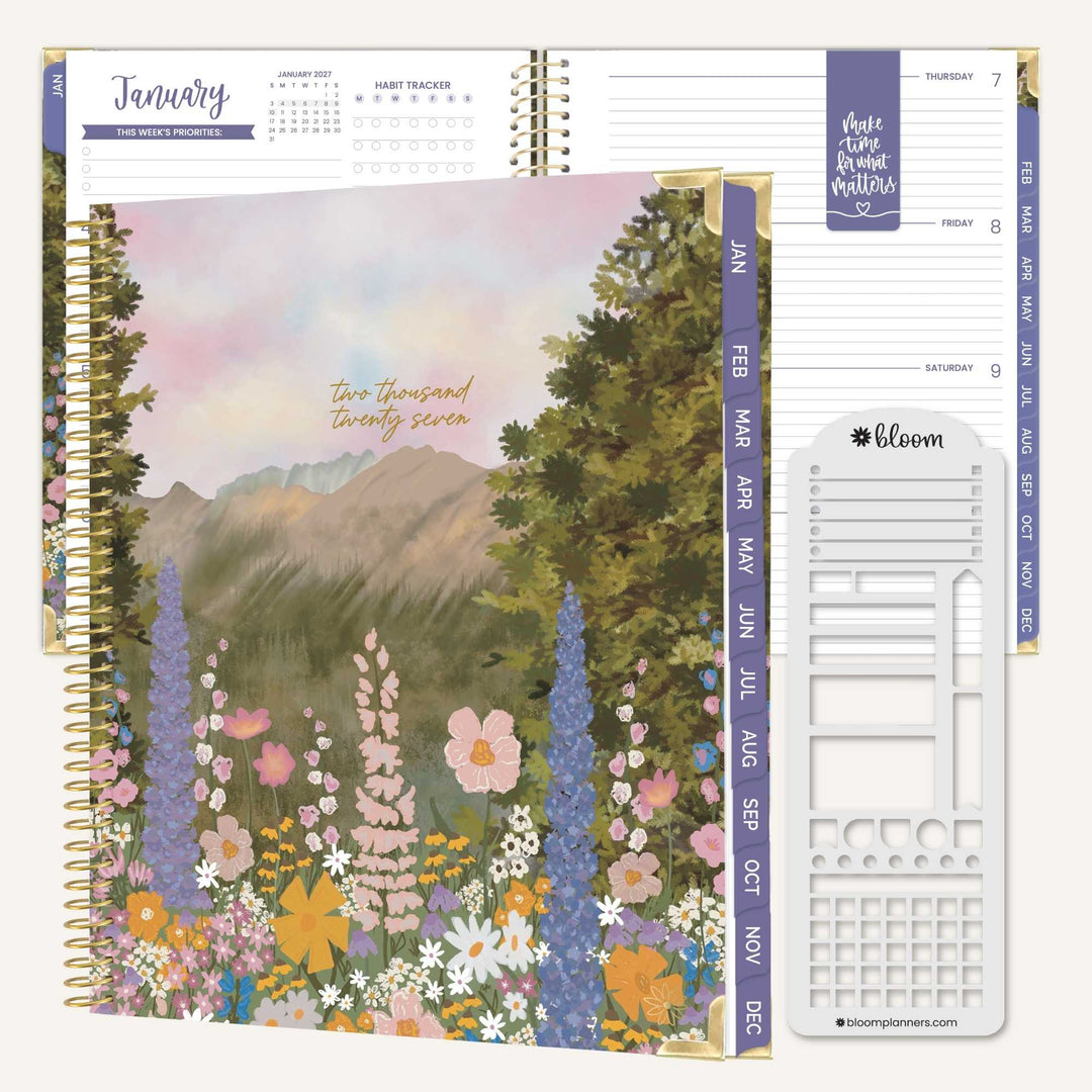 A Bloom planner set shown on a white background, featuring a floral mountain landscape cover, interior monthly dividers, and a white weekly page insert.