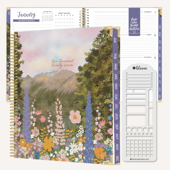 A Bloom planner set shown on a white background, featuring a floral mountain landscape cover, interior monthly dividers, and a white weekly page insert.
